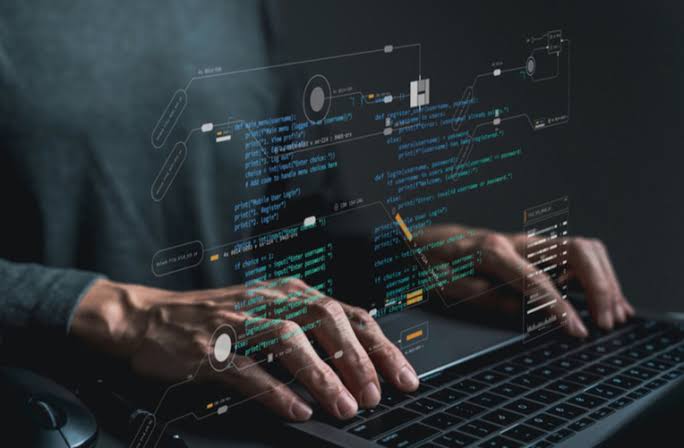 Developer coding on a laptop with programming diagrams, representing success with web development frameworks and processes